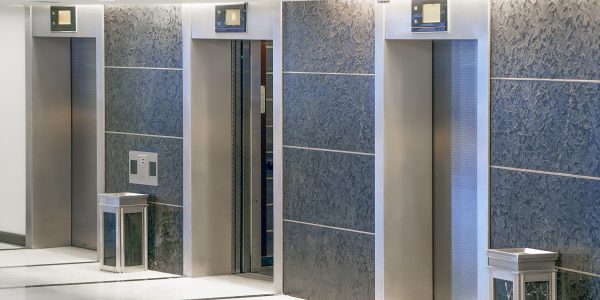 Three,Elevator,Doors,In,Office,Building.,Wide,Angle,View,Of