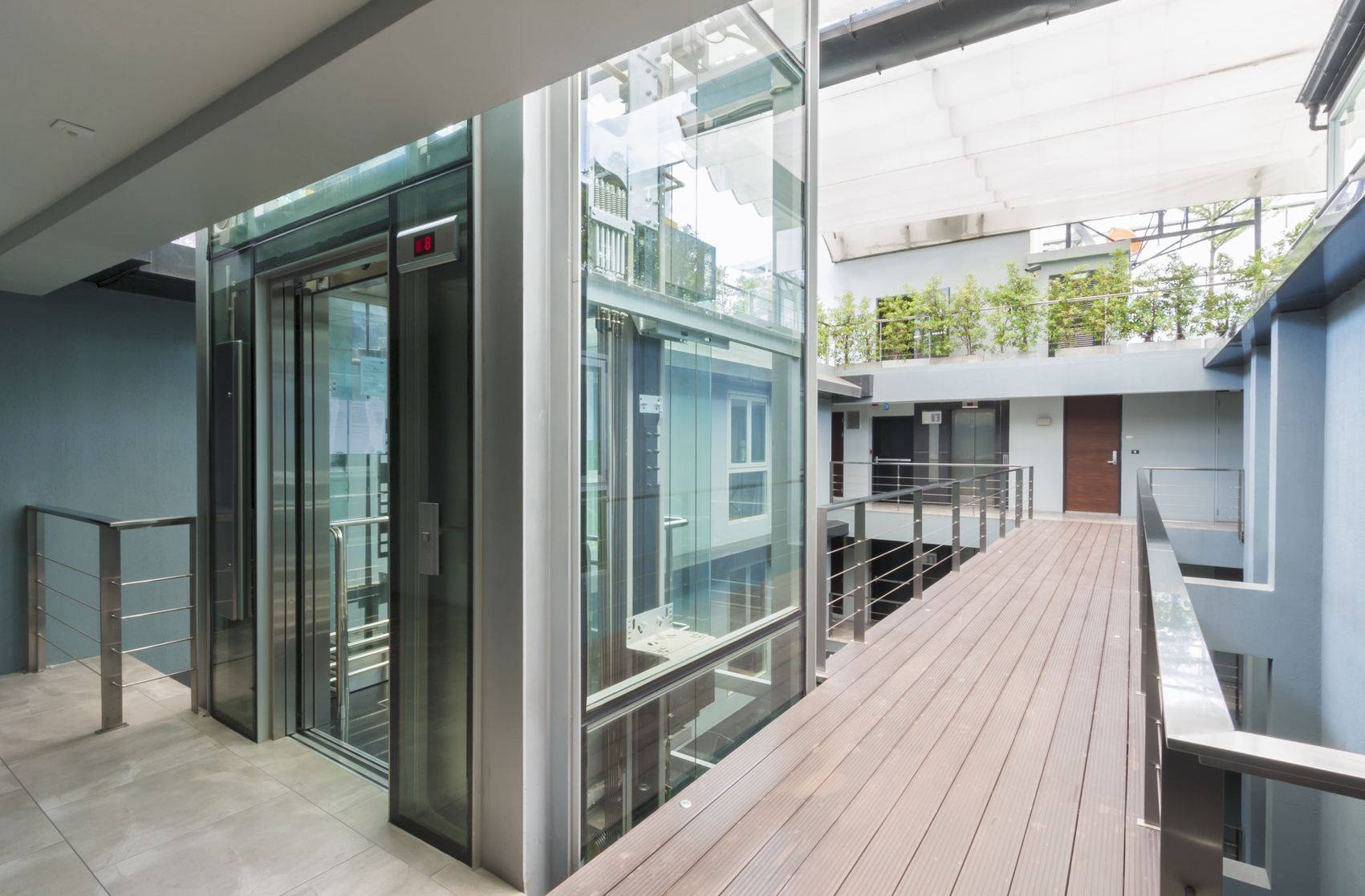 apartment interior with walkway bridge and glass lift opened.